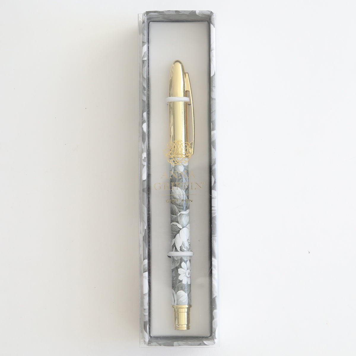 The Grey Roses Gift Pen, featuring a floral design and gold accents, is elegantly presented in a rectangular box with a clear lid, ideal for any stationery enthusiast.
