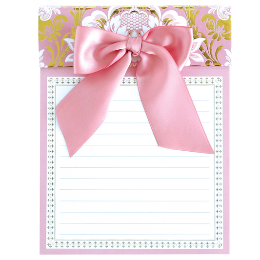 The Pink Damask Bow Pad is a pink and gold decorative notepad featuring a large pink bow on top, lined sheets, and perforated pages for easy tearing.
