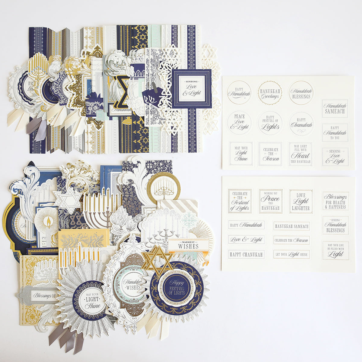 Hanukkah Card Toppers and Sentiments in blue, gold, white, and cream are arranged neatly on a white background, featuring assorted decorative elements and stickers for card making.