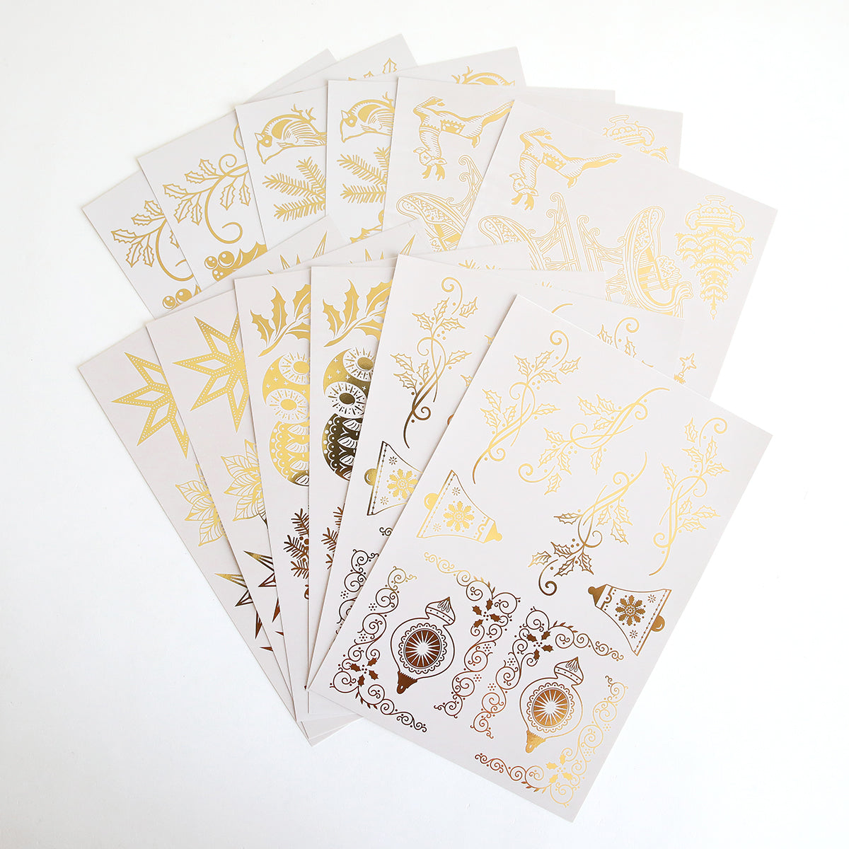 Holiday Foil Rub On Transfers feature metallic gold and bronze floral and ornamental designs in a fan shape on white—ideal for adding shimmer to your crafts.