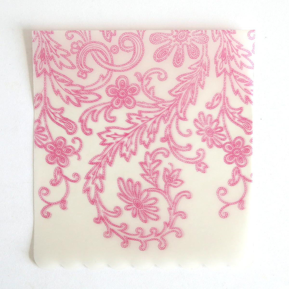 The Pink Lace Vellum Wrap 10 pack features square, translucent sheets with pink floral and leaf patterns, intricate swirls, and a scalloped bottom edge—ideal for elegant wedding invitation wraps and displayed on a white background.
