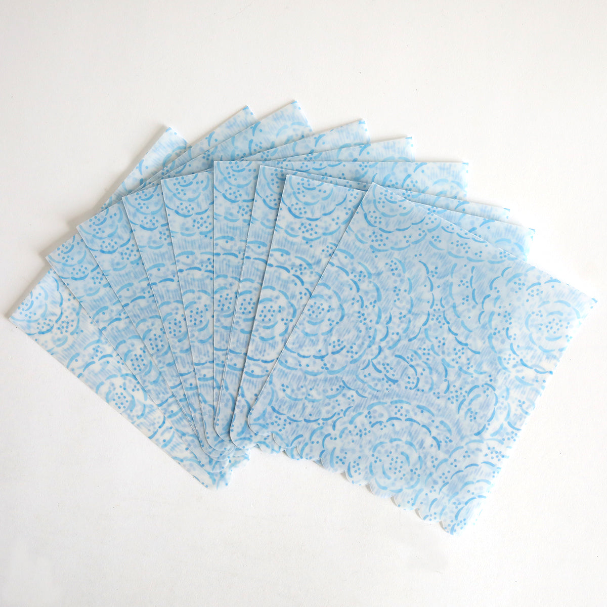 The Blue Vellum Wrap 10 pack features ten blue patterned paper napkins displayed in a fan shape on a white background.