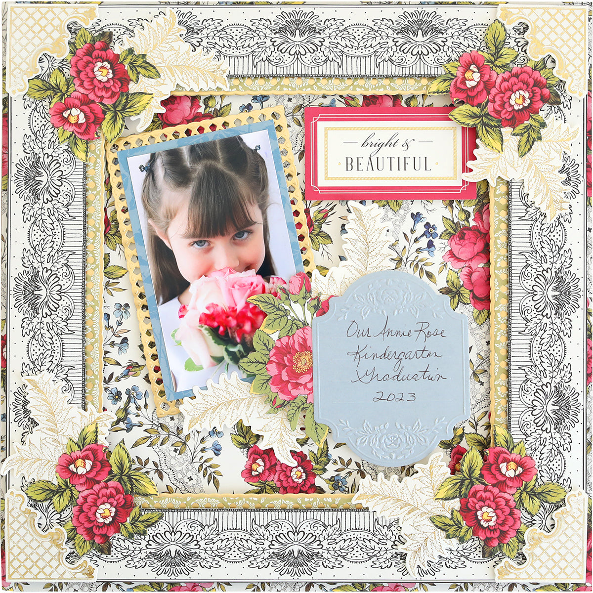 A girl with bangs smelling pink roses, featured on a decorative scrapbook page with floral embossing and the text "beautiful" and "our little rose kindergarten graduate 2023.