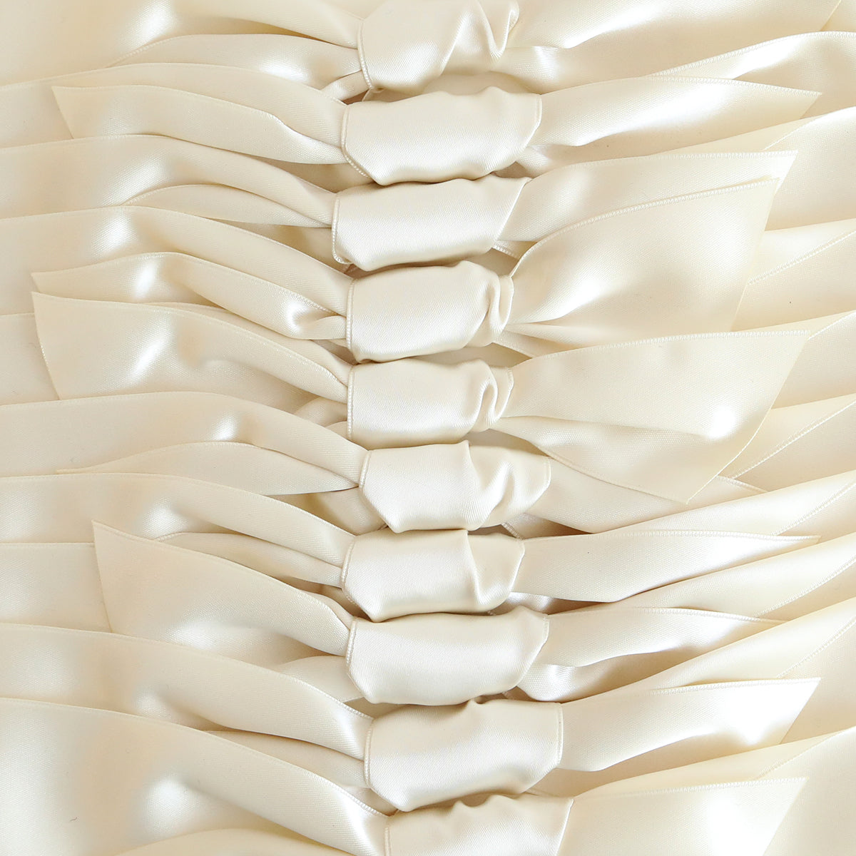 A close-up of Ivory Satin Knots 10 count arranged in neat, horizontal rows—perfect elegant accents for handmade cards.