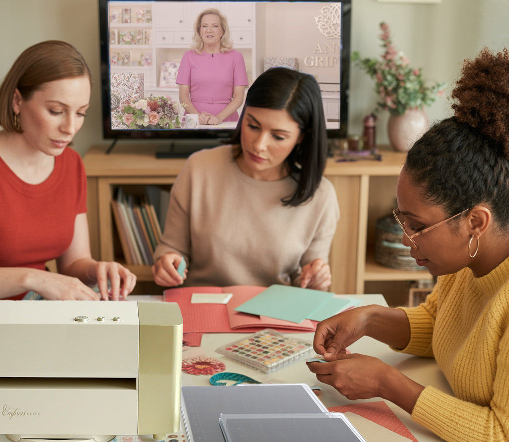 An illustration of Anna Griffin | Create 2025 with a TV in the background showing a crafting tutorial.