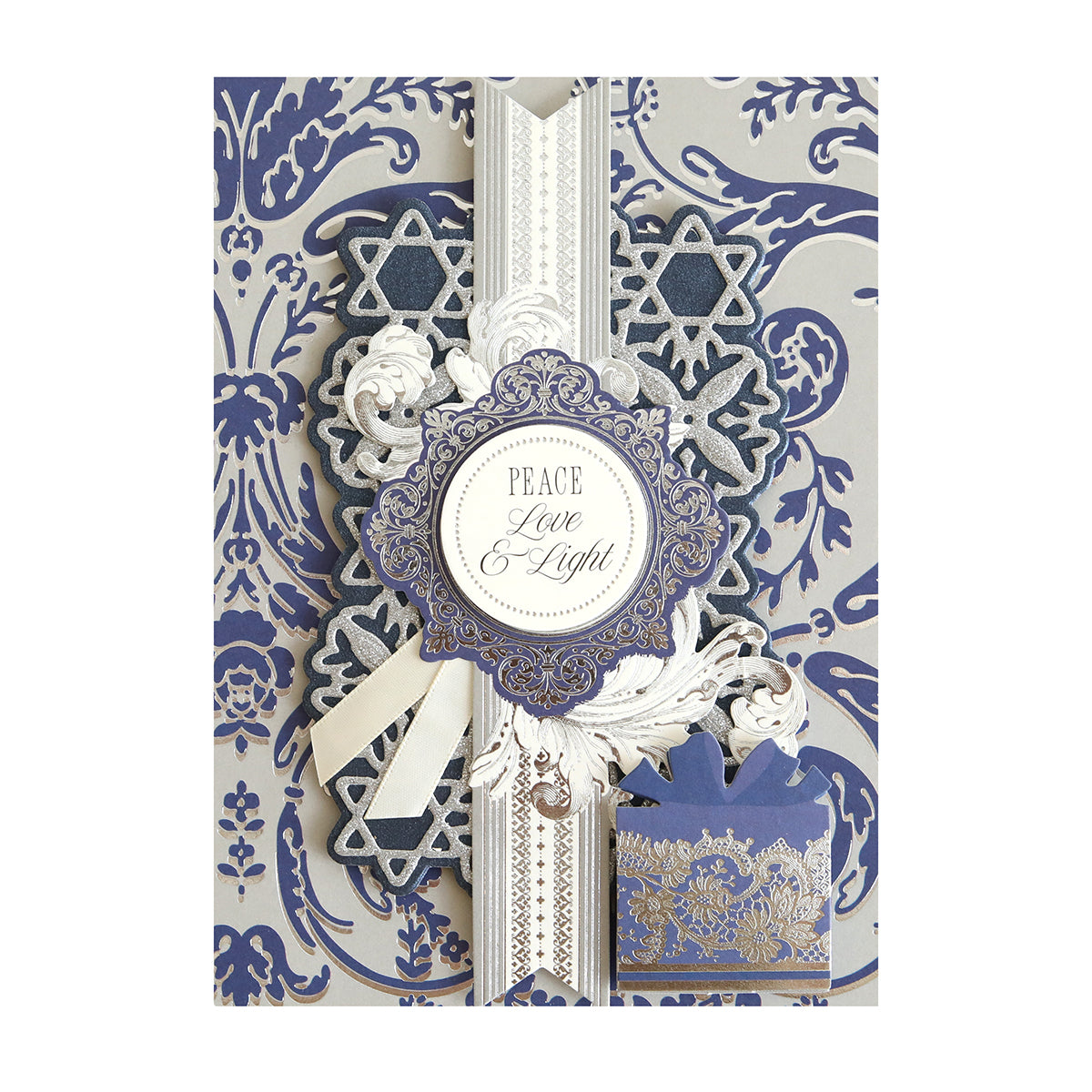 A decorative Hanukkah card made with Luxury Luster Foil Cardstock, featuring blue, silver, and white patterns, Star of David symbols, and the message "Peace Love & Light"—ideal for festive crafts.