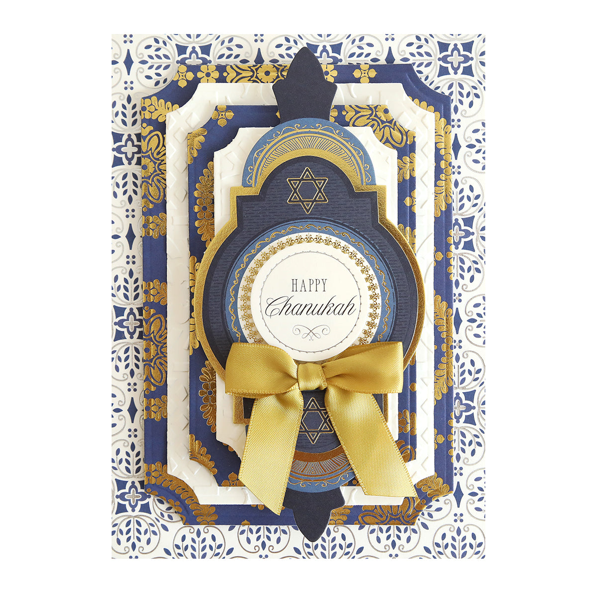A decorative Hanukkah card made with Luxury Luster Foil Cardstock, featuring layered blue, white, and gold patterns, a gold bow, and "Happy Chanukah" as the central message.