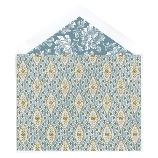 The Blue Harlequin Note Cards feature folded cards paired with envelopes that have a floral interior design. The exterior displays gold and light blue floral motifs on a blue geometric background.