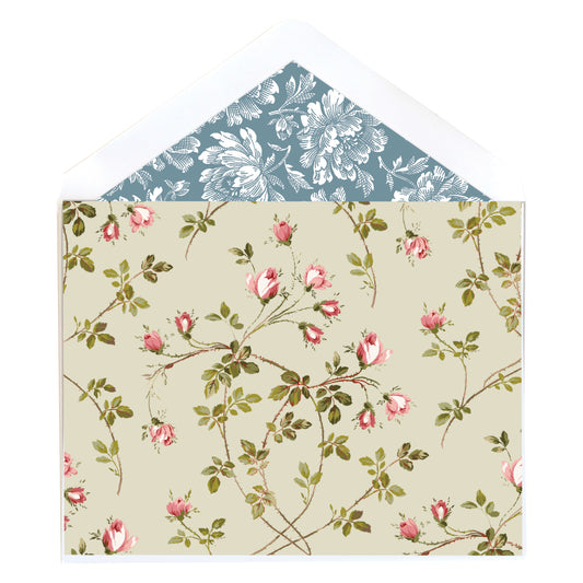 The Small Flowers Note Cards feature an open envelope with a pink floral and green leaf exterior, while the lined interior boasts a blue background with white floral patterns.