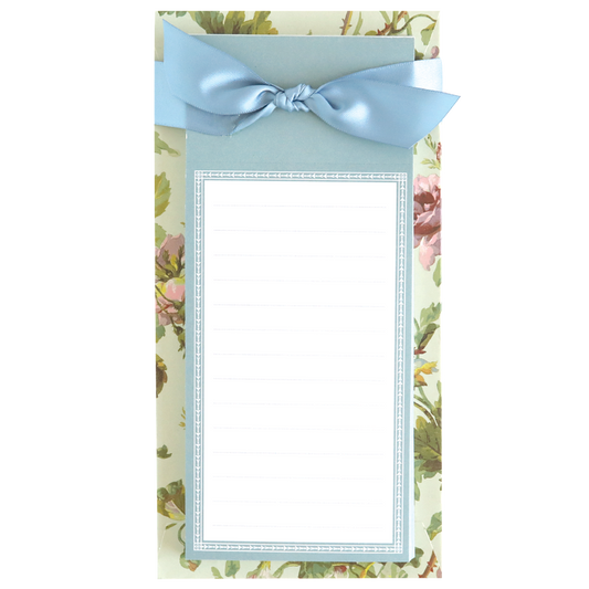 The Francesca List Pad is a charming floral notepad with a blue ribbon at the top, perfect for grocery lists or to-do lists. Featuring blank lined paper, it's ideal for organizing thoughts and plans.