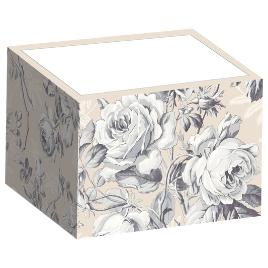 The Faded Rose Notepad Block is a cube featuring grayscale roses and leaves on a beige background.