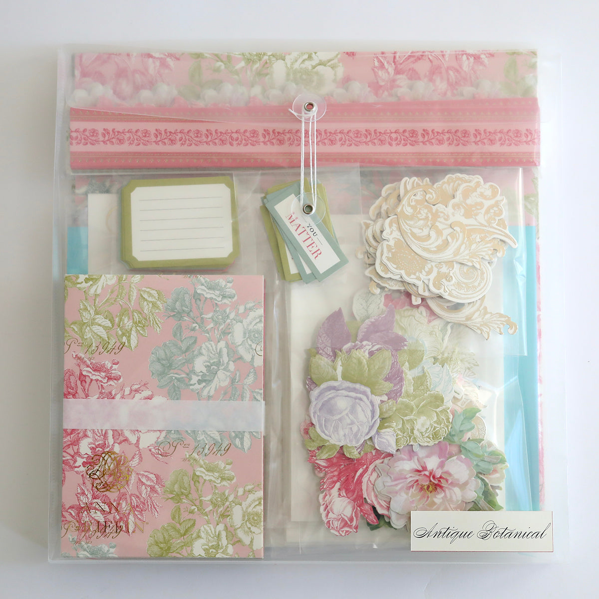 The Crop at Home 5 Ultimate Materials Kit is a stationery set featuring floral note cards, labels, tags, and pastel cardstock cutouts—ideal for scrapbook lovers. Labeled "Antique Botanical.