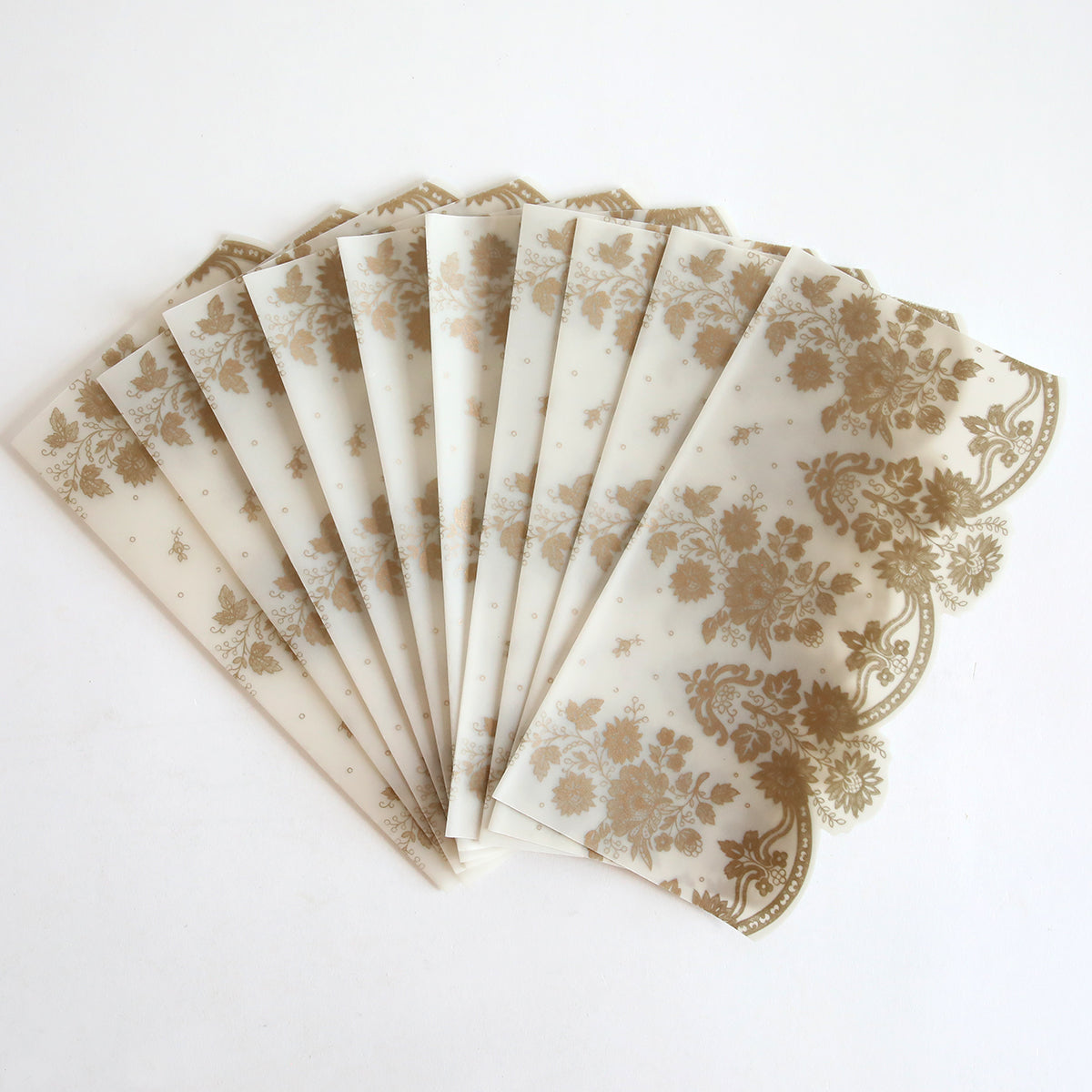 The Gold Vellum Side Wrap 10 pack features semi-transparent wraps with a gold floral pattern, perfect for wedding invitations. Shown fanned out on a white surface.