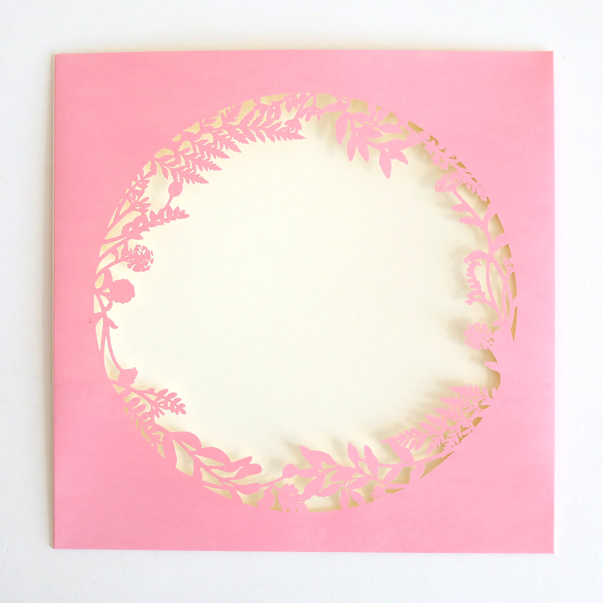 The Pink Lasercut Circle Sleeve 10 pack features a circular design with an intricate floral cutout surrounding a blank cream-colored center.