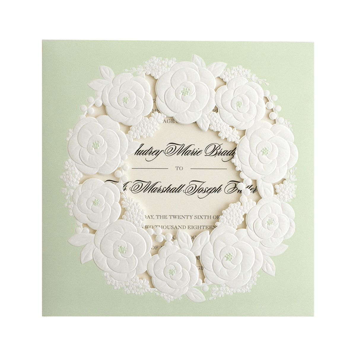 A wedding invitation with white flowers on a green background.