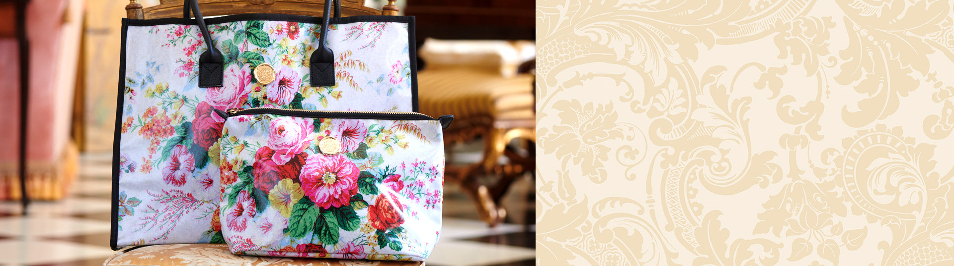 Two floral patterned bags, one larger tote with black handles and a smaller pouch, displayed on a cushioned chair in a brightly lit room.