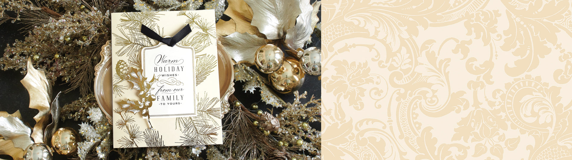 A festive card with gold and black foliage designs reads "Warm Holiday Wishes from our family to yours," adorned with a gold pine cone ornament and a black ribbon.