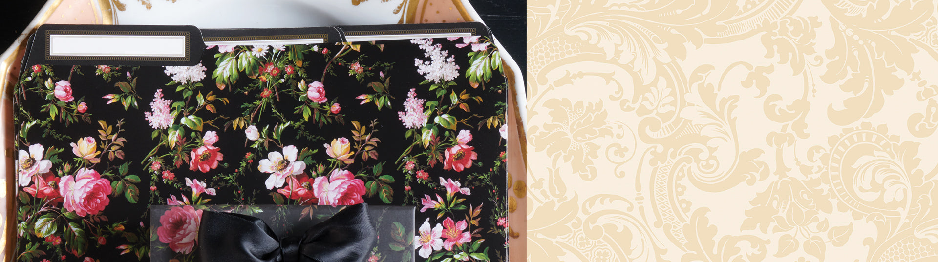 A set of floral-themed stationery, including a folder, bow-tied notepad, and a note sheet with a rose gold pen, arranged on a decorative tray.