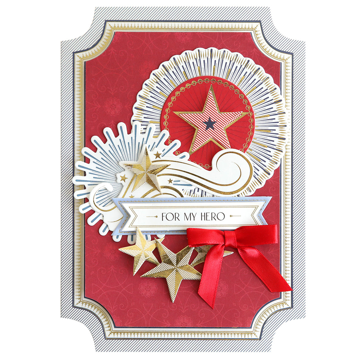 The Simply Celebration Chest Card Making Kit includes a greeting card with gold stars, decorative patterns, a red bow on a red and gold background, and 3D embellishments. The card features "FOR MY HERO" in a banner at the center.