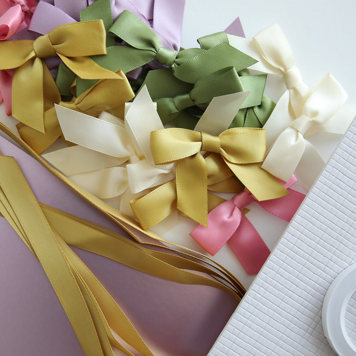 Crop at Home 5 Swag Materials: Assorted satin ribbon bows in green, cream, gold, pink, and lavender with matching ribbon strips—perfect for crafting your next Crop at Home 5 project.