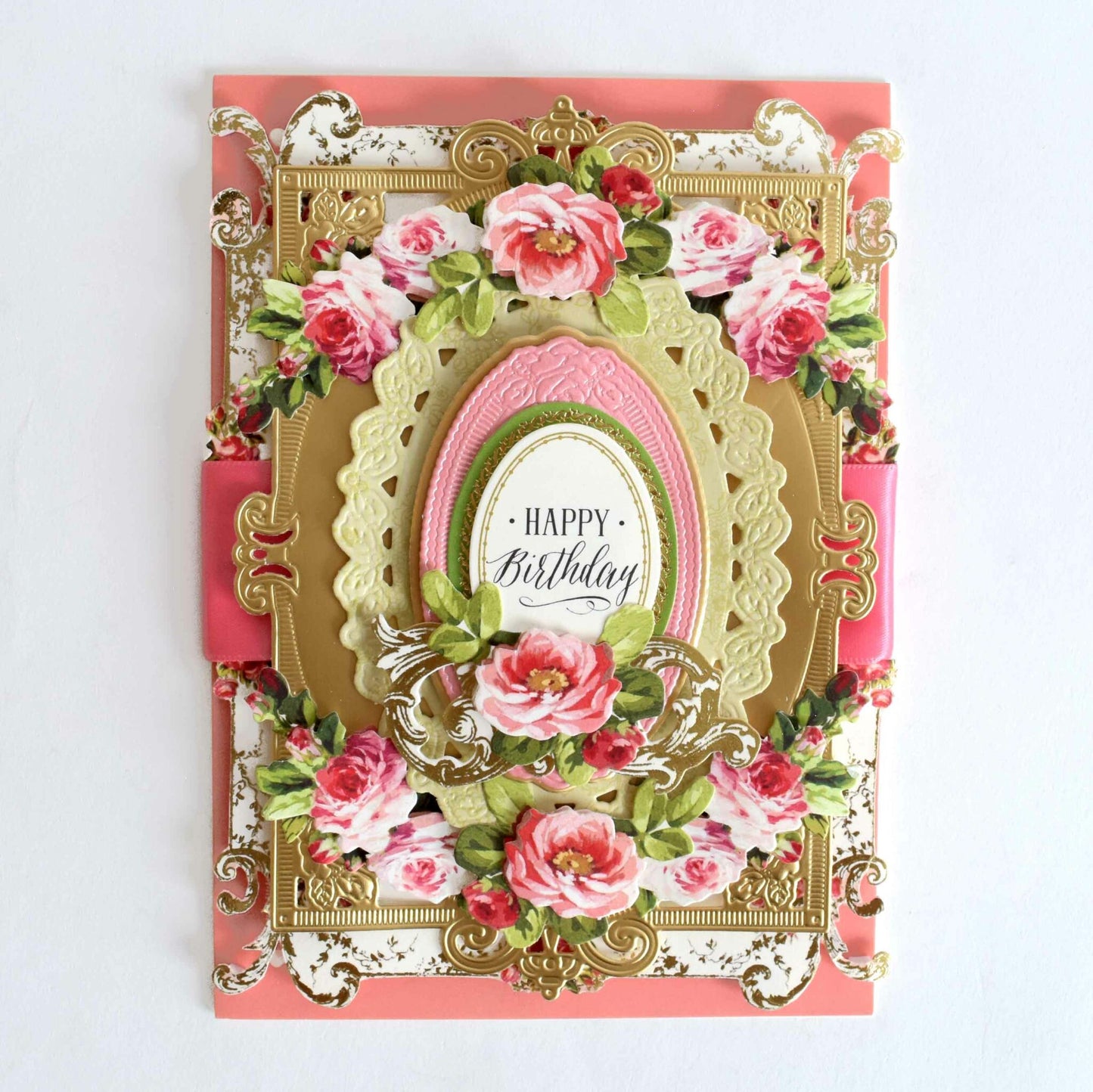 a pink and gold birthday card with flowers.