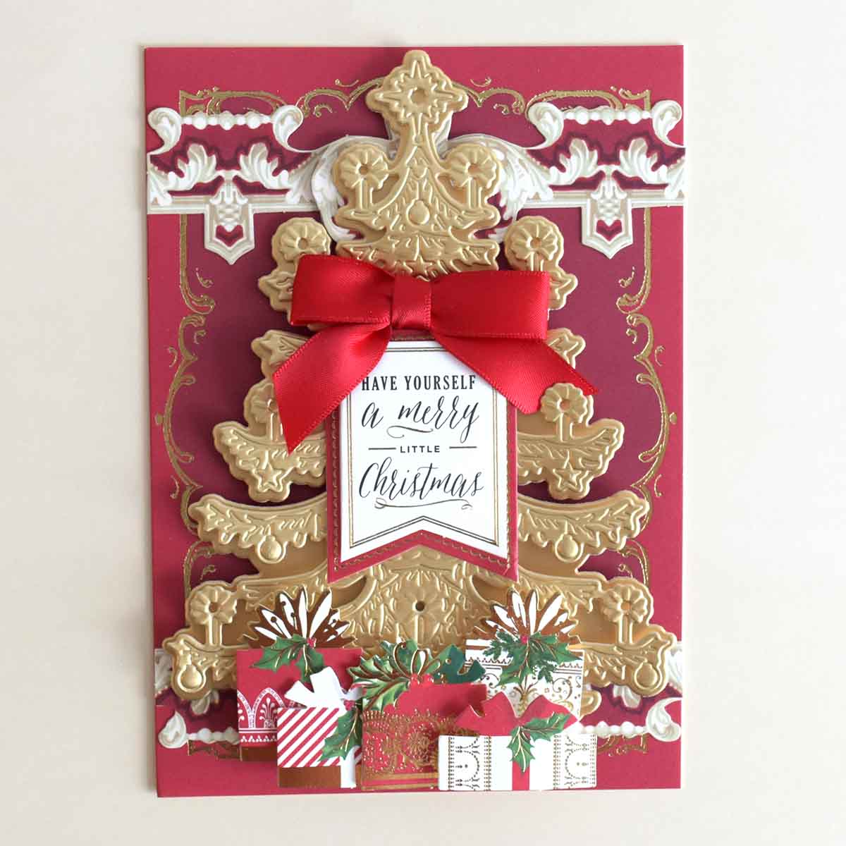 a red and gold christmas card with a red bow.