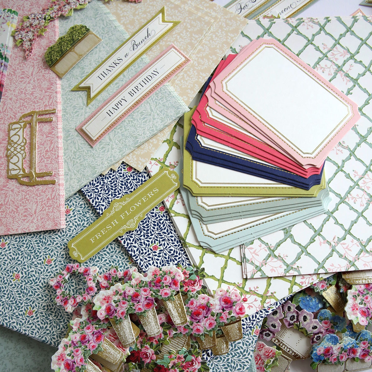 A pile of Flower Shop Easel Finishing School Kit cards and papers on a table.