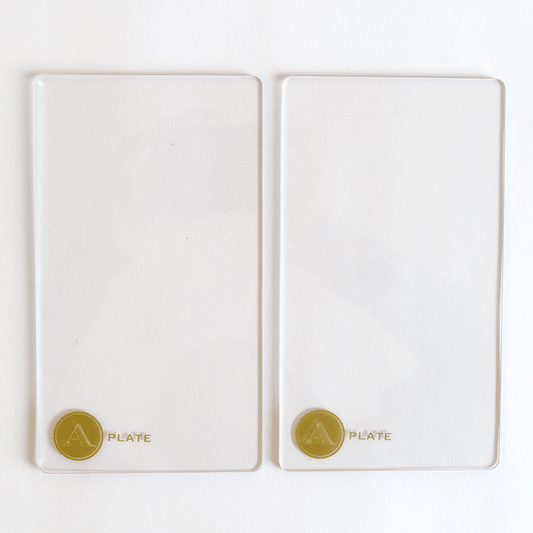 a couple of white plates sitting on top of a white table.