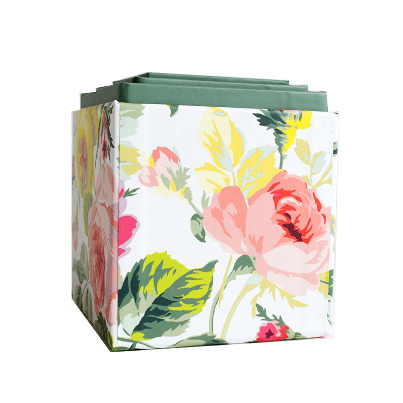a floral shopping bag with a green handle.