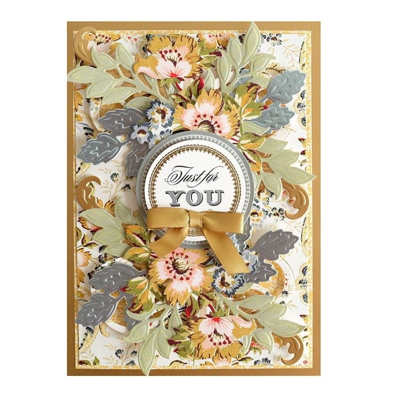 a handmade card with flowers and a ribbon.