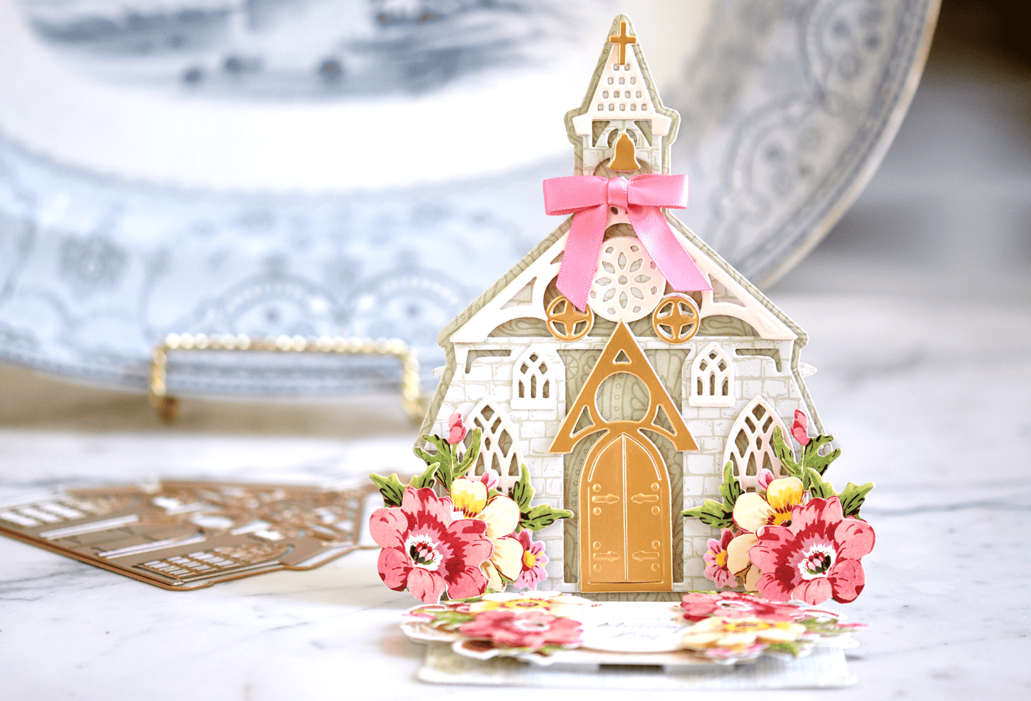 a paper house with a pink bow on top of it.