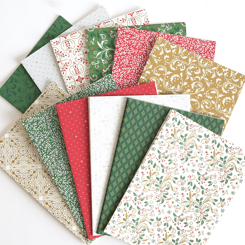 a pile of christmas paper sitting on top of each other.