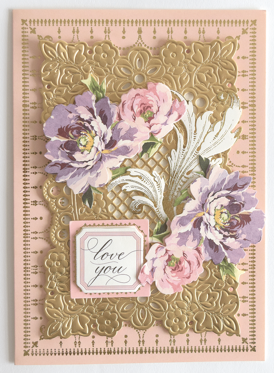 a pink and gold card with flowers on it.