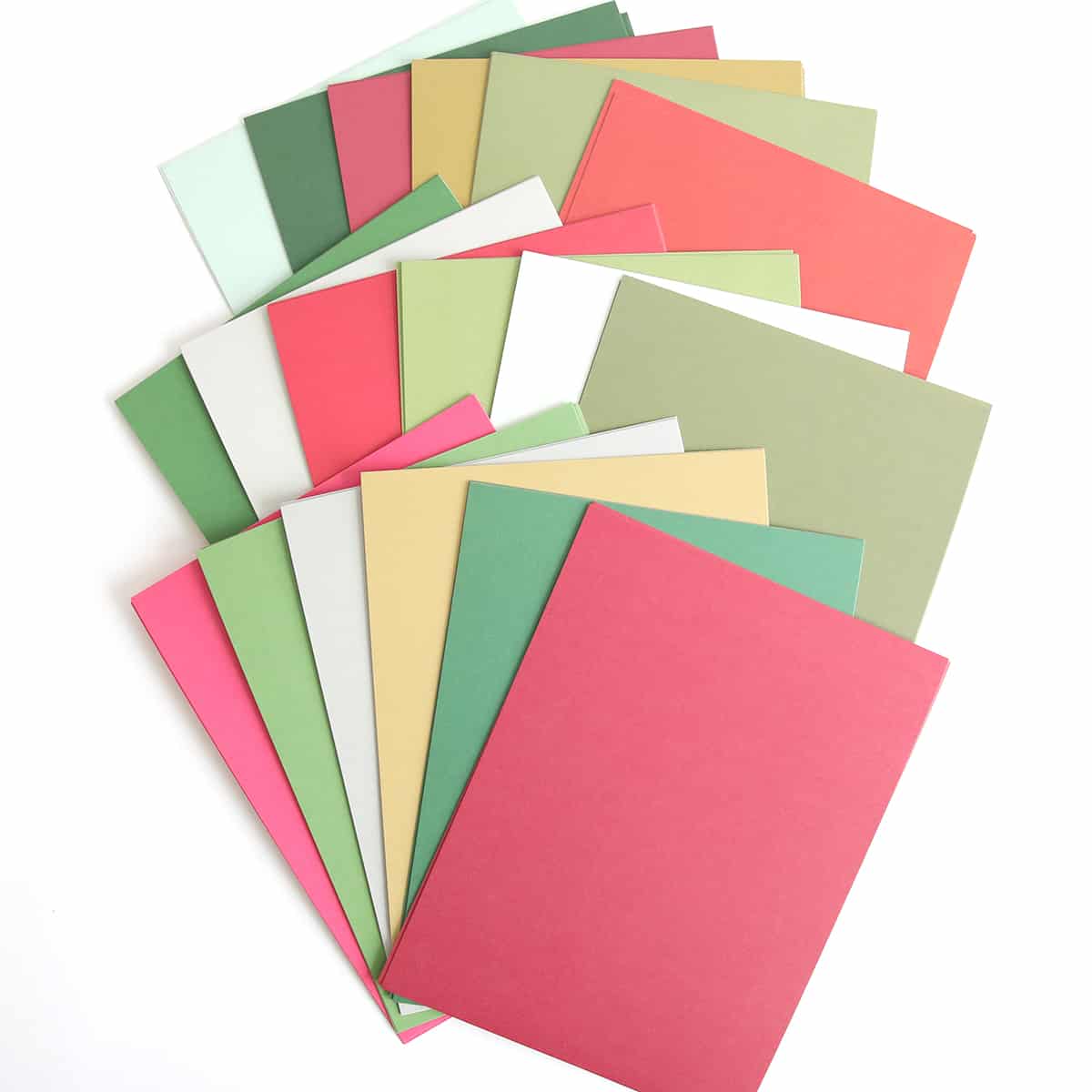 a pile of different colored papers on a white surface.