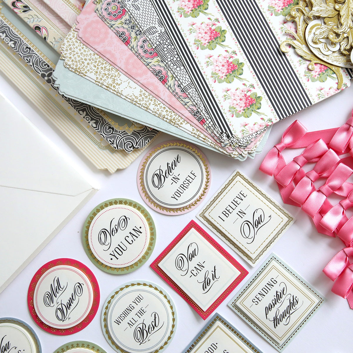 A table topped with lots of different types of paper from the Simply Encouragement Card Making Kit.