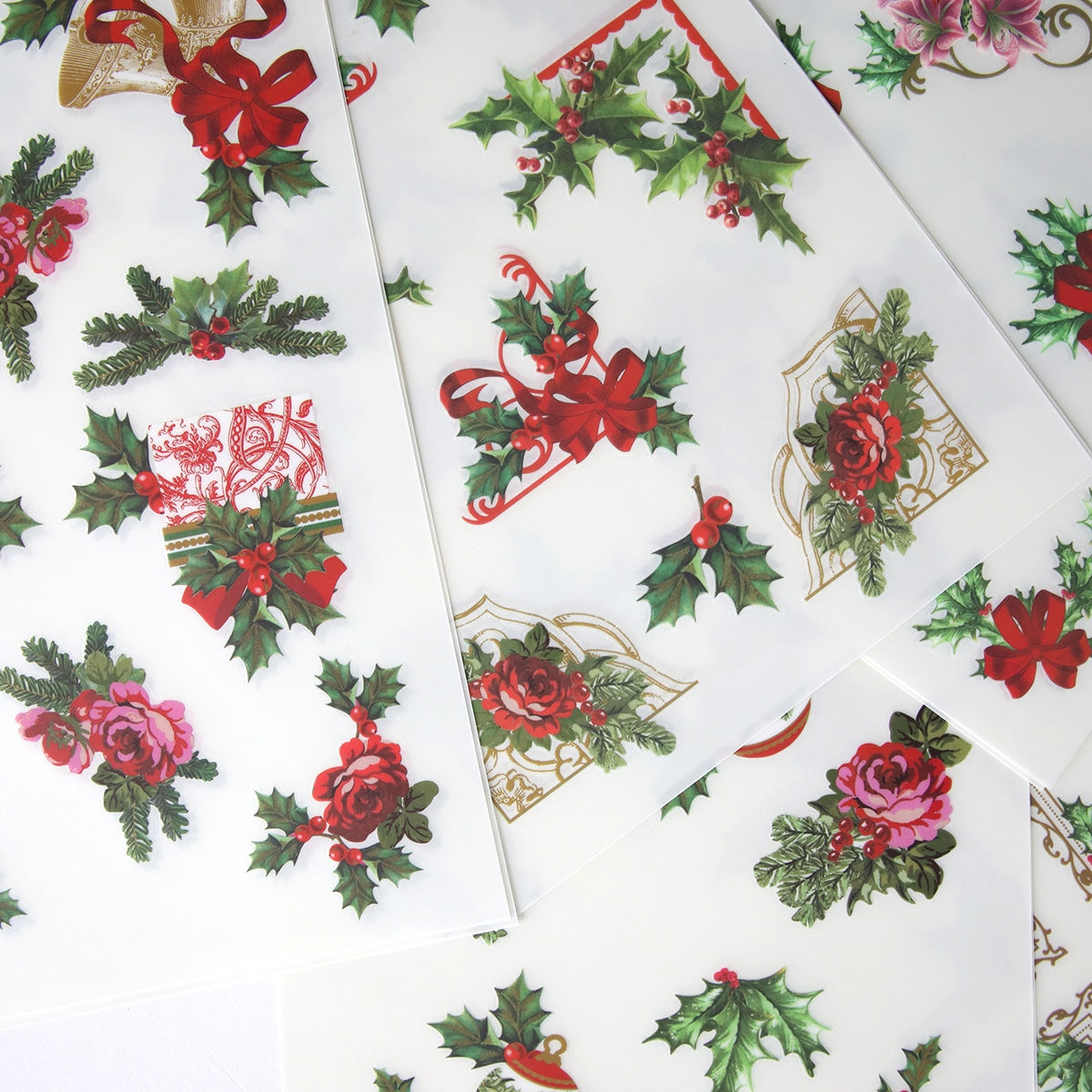 Christmas Ephemera Rub Ons leaves and Christmas Ephemera Rub Ons berries on a white sheet of paper.