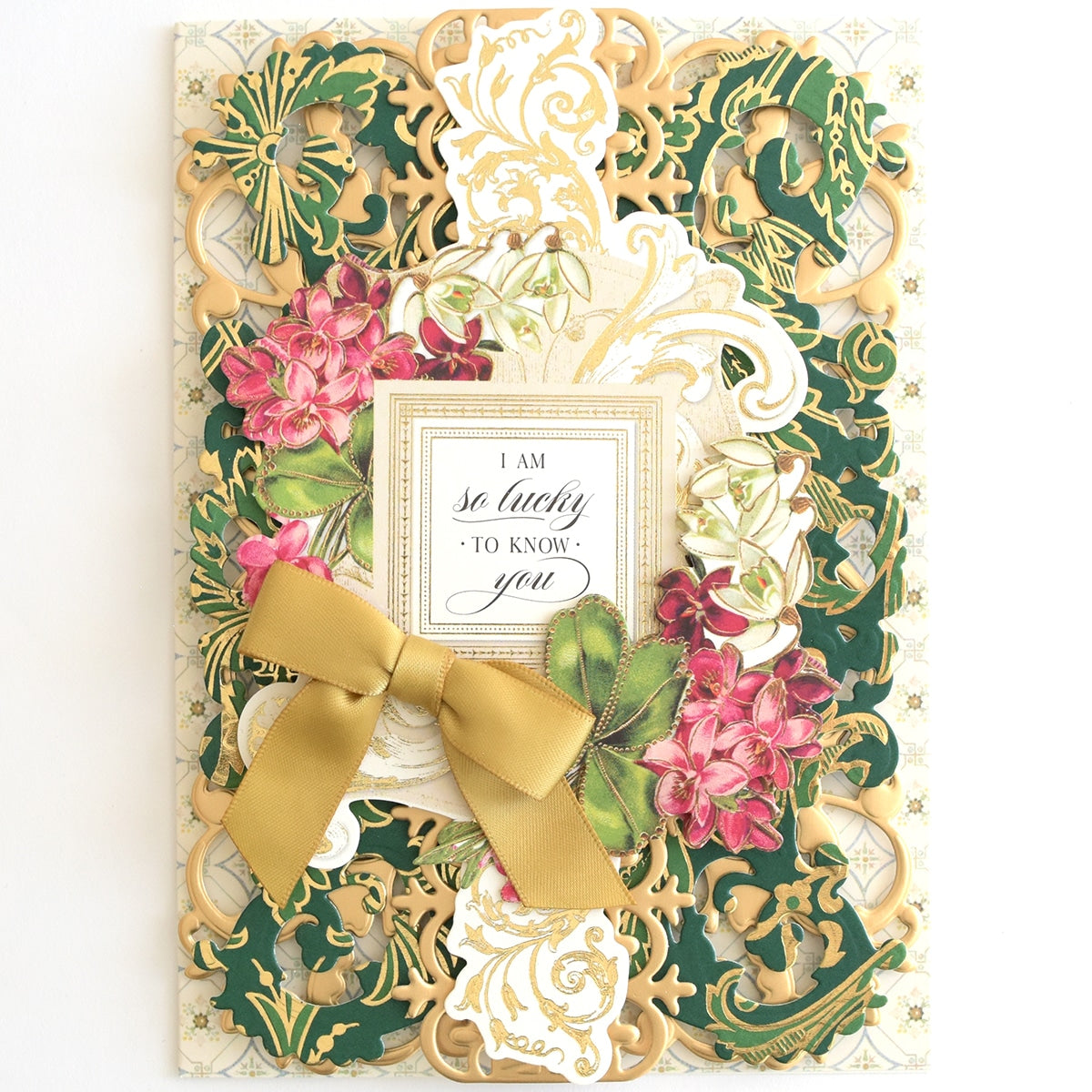 a card with a gold bow on top of it.