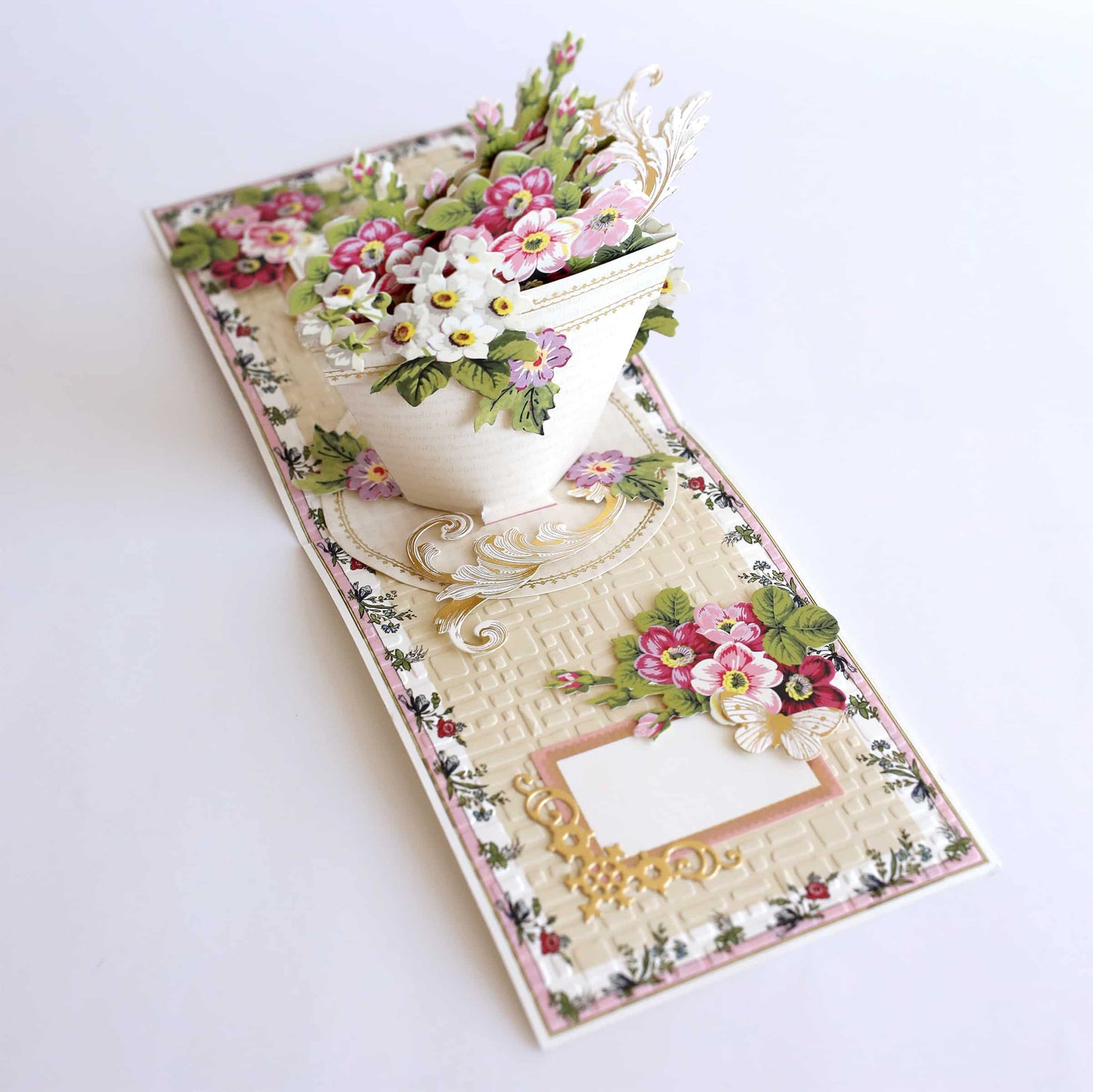 a white vase with flowers on a table.