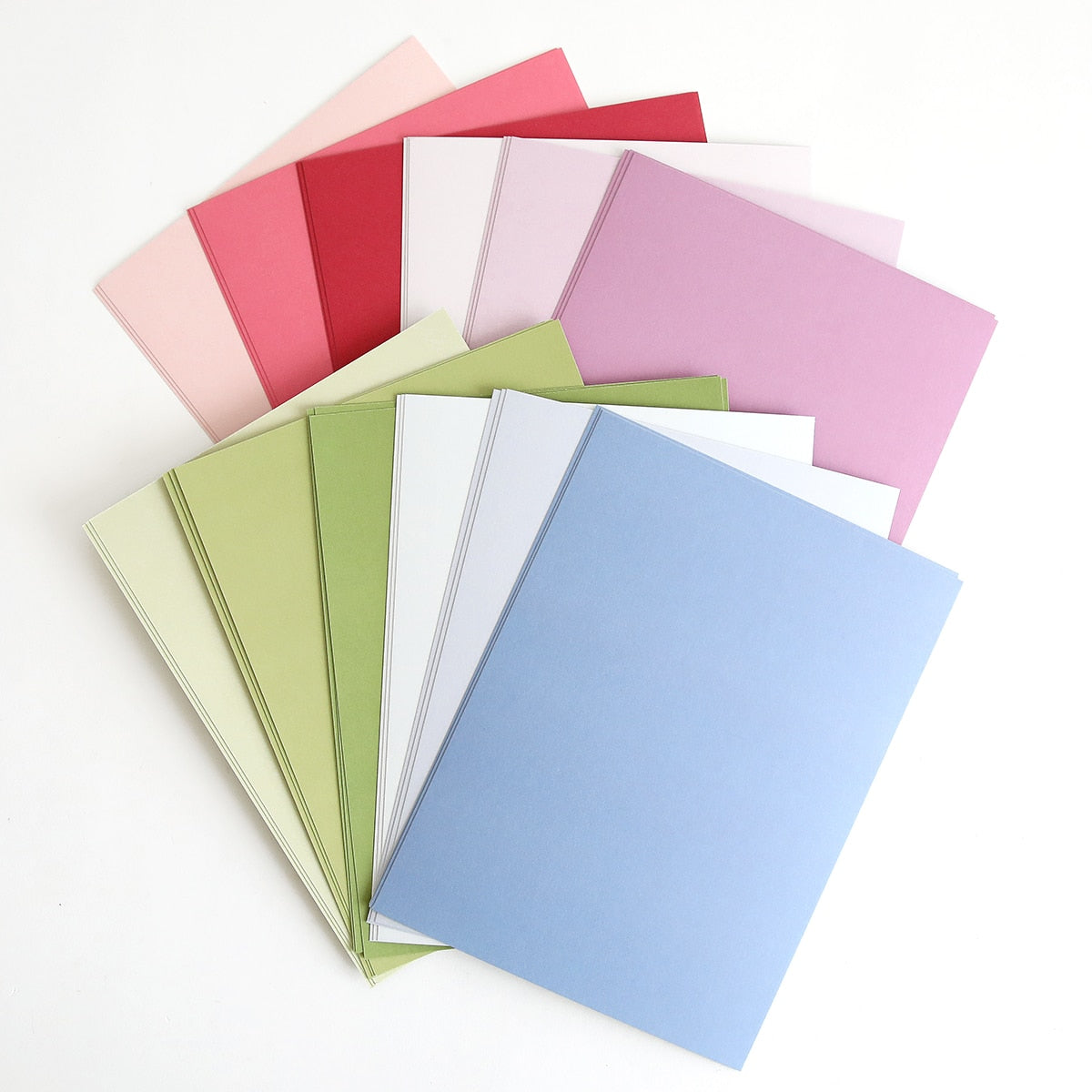 a bunch of different colors of paper on a white surface.