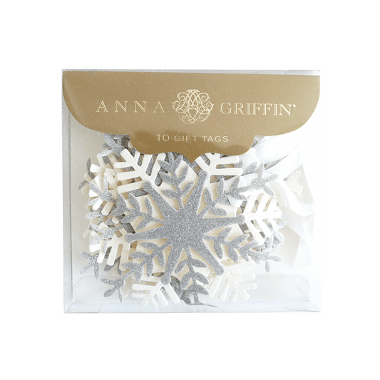 a white snowflake with a gold tag on it.