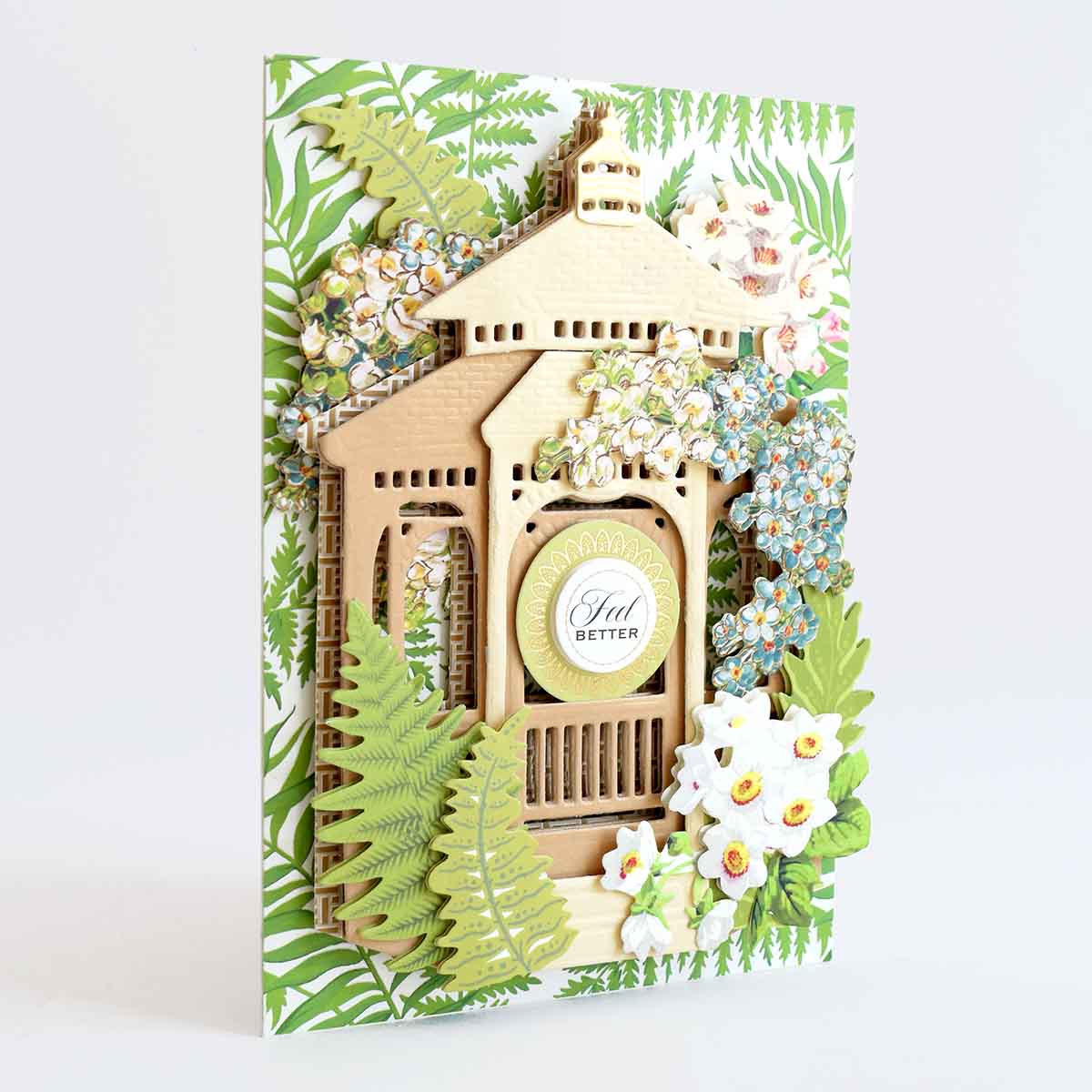 a card with a picture of a house surrounded by flowers.