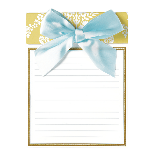 a notepad with a blue bow on top of it.