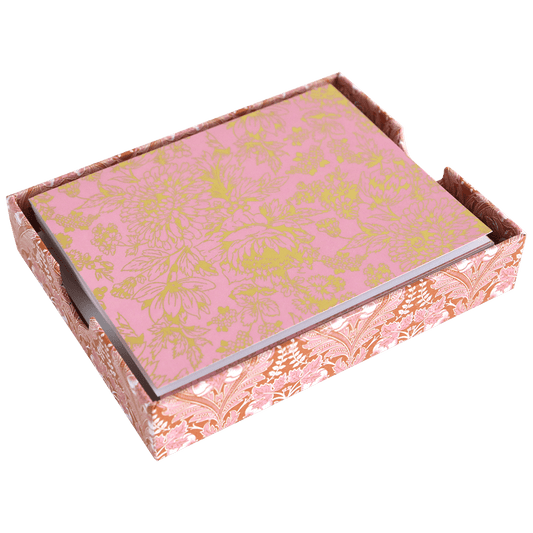 a pink and gold box with flowers on it.