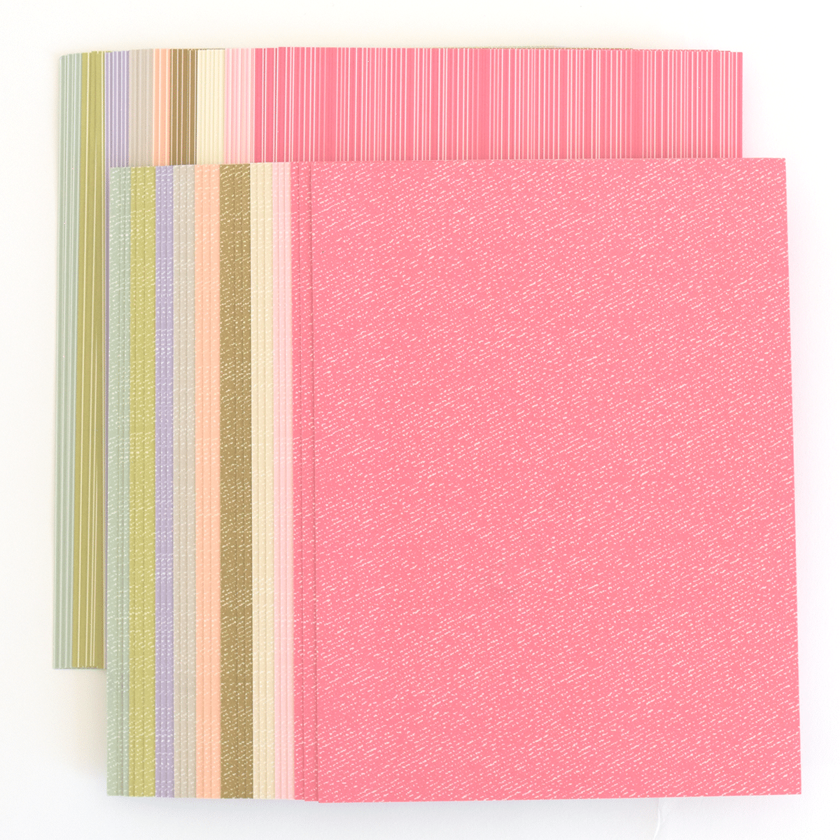a set of three different colored papers on a white surface.