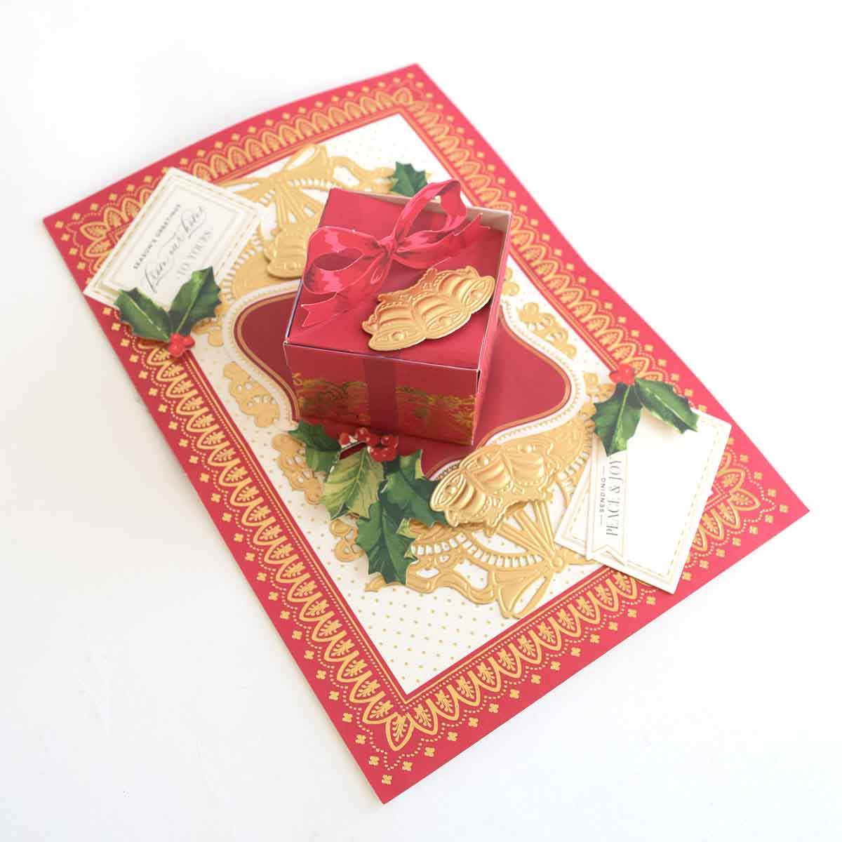 a red gift box with a red bow on top of it.