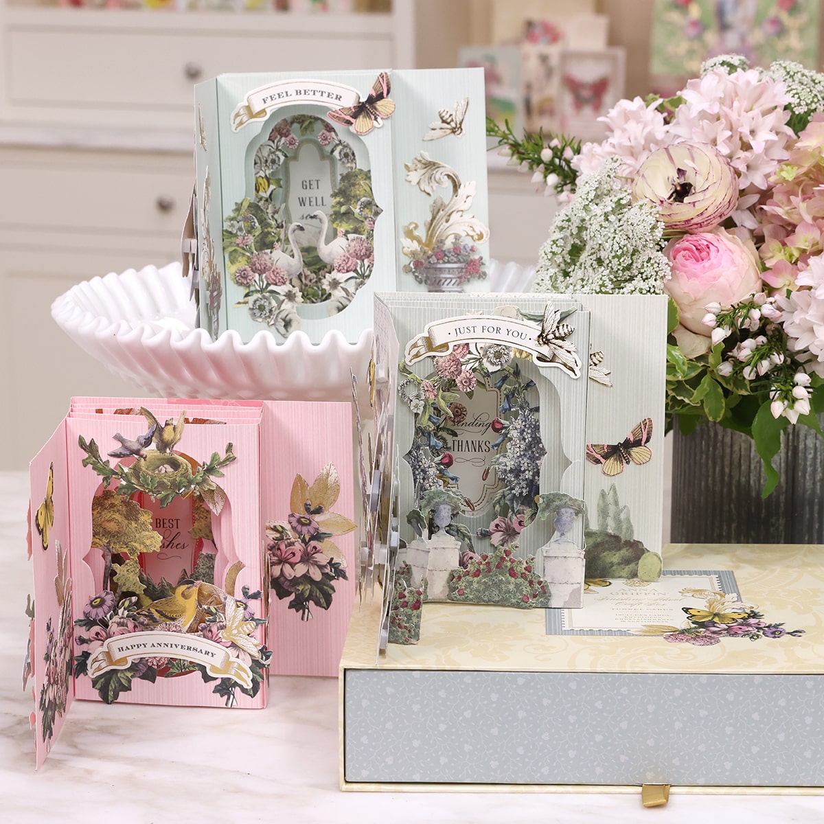 a table topped with cards and vases filled with flowers.
