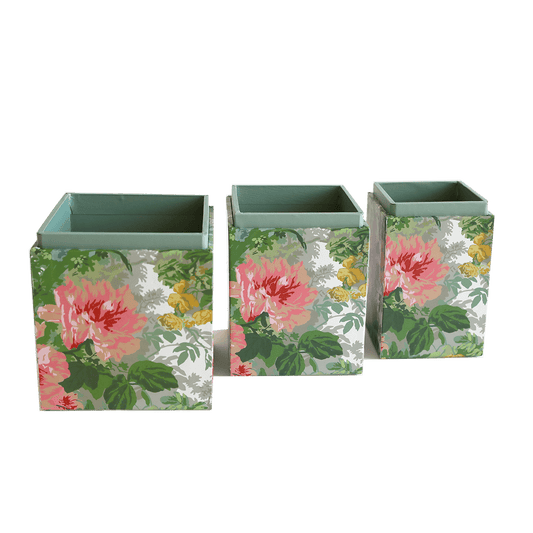 a set of three vases sitting on top of a green surface.