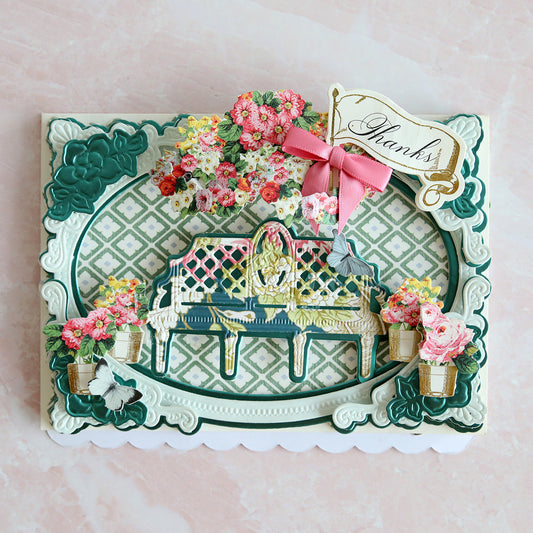 blue and green layered card with flowers and a floral bench in the middle