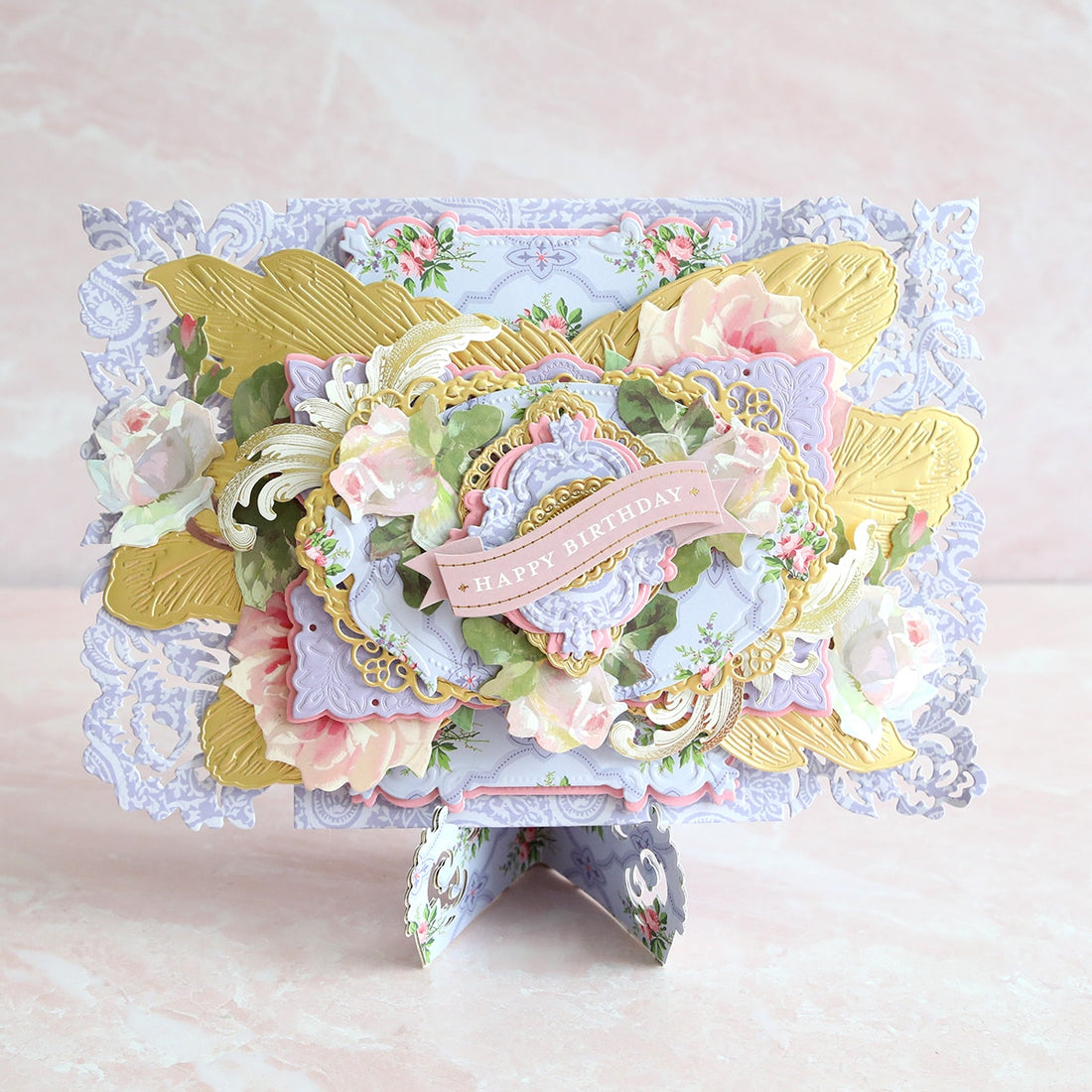 a card with flowers and lace on a pink background.