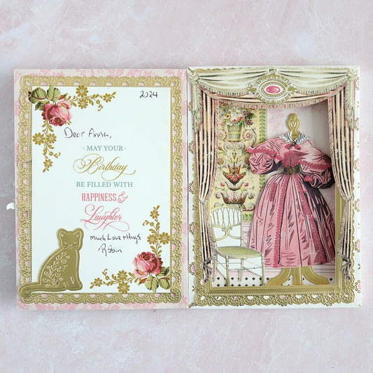 A diorama scene with vignette, cat and Victorian paper dress